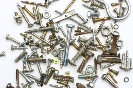A pile of nuts,bolts, screws and other fasteners on a white background