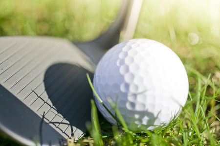 Lofted wedge resting behind a golf ballの写真素材