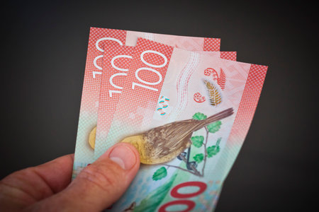 New Zealand currency. Hundred dollar notes held fanned out in hand