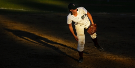 SHERBROOKE, CANADA - August 5: New Brunswick's Sydney DeBortoli is spotlighted by the setting sun in women's softball at the Canada Games August 5, 2013 in Sherbrooke, Canada.のeditorial素材