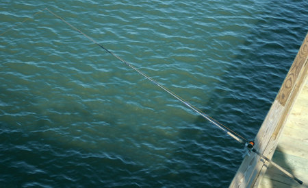 A fishing pole on a fishing pier.