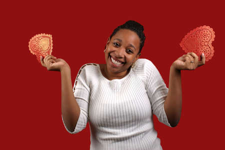A pretty young woman holding a two paper valentines.の写真素材