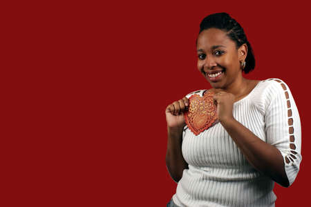 A pretty young woman holding a paper valentine.の写真素材
