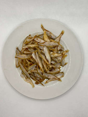 Small dry fish from the sun on the white background, pattern of dried fish and small dried fish.の写真素材