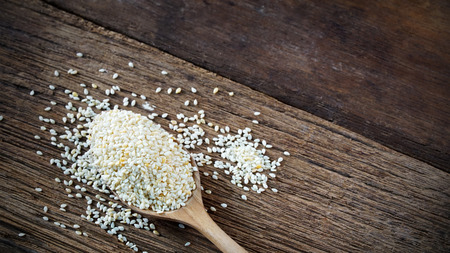 White sesame seeds in wooden spoonの写真素材