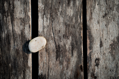 White zen stone on wood ground の写真素材