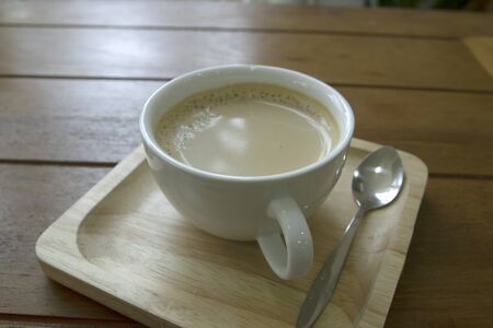 Coffee in a white mug on a wooden tableの写真素材