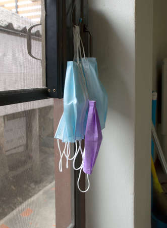 A face mask used to prevent the Corona virus from hanging by the door.の写真素材