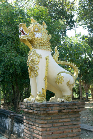Ancient lion statue in front of the door of a Thai temple