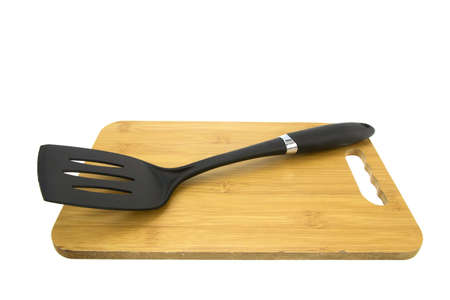 Plastic turner and wooden cutting board isolated on white background.の写真素材