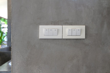 Six light switch on grey concrete wall.