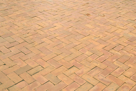The public walkway is made of beautifully made red bricks.