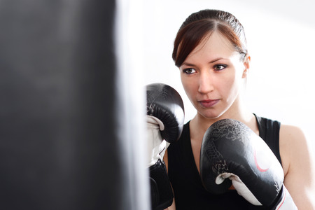 Woman working out on punch bag in gymの写真素材