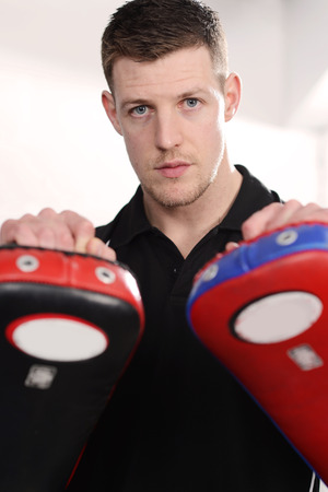 Male personal trainer with work-out padsの写真素材