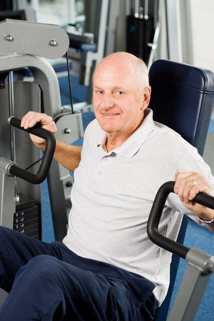 Mature older man working out in the gymの写真素材