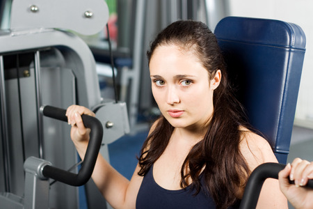 Attractive young woman exercising in the gymの写真素材