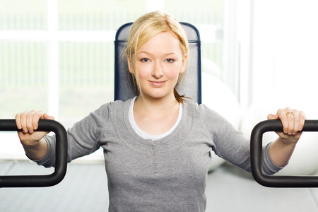 Young attractive blond girl exercising at the gymの写真素材