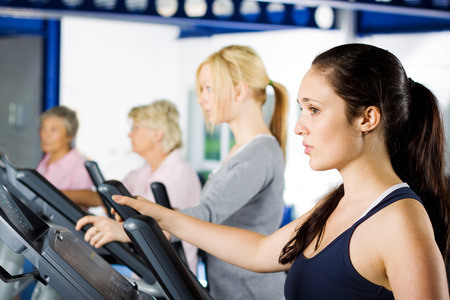 Beautiful brunette girl working out at the gym with a group of friendsの写真素材