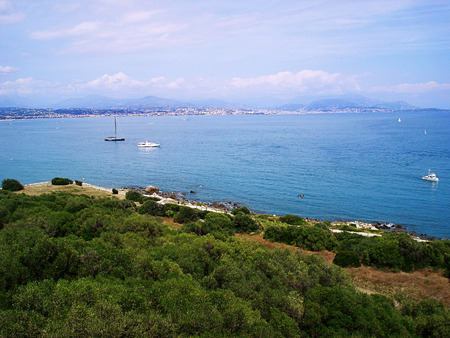 Walls of a fort go down directly to water. From here the wonderful panoramic view of the Antibes city, its port and the cape Garup on the one hand both a bay of Angels, and the Alps ridges on the other hand opensの写真素材