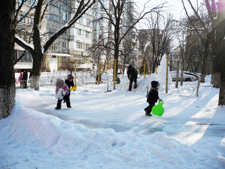Kiev, Ukraine - January 24, 2016: The children rush to slide down from hill in the winter.のeditorial素材