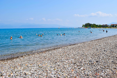 Kamena Vourla, Greece - July 14, 2017: Vacationers on the pebble beach at summer sunny morning.のeditorial素材