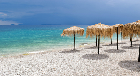 Straw umbrellas on sunny beach of Kineta, Greece.の写真素材