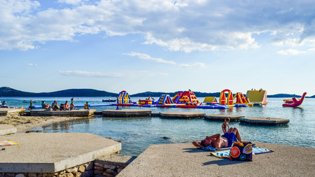 Vodice, Croatia - July 9, 2018: Vacationers on the beautiful pebble beach.のeditorial素材