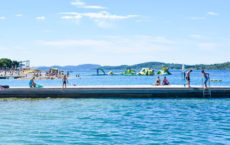 Vodice, Croatia - July 8, 2018: Vacationers on the beautiful pebble beach.のeditorial素材