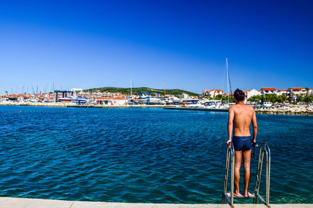 The guy on the stairs on the background of Vodice cityscape, Croatia.のeditorial素材