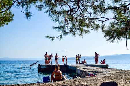 Baska Pole, Croatia - July 12, 2018: Vacationers on the public beach Baska Pole.