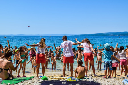 Promajna, Croatia - July 11, 2018: Animators "Neptune Club" and vacationers on the beach.のeditorial素材