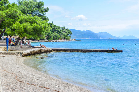 Orebic, Croatia - July 17, 2018: Vacationers on the beautiful pebble beach.