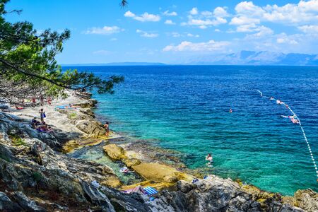 Trpanj, Peljesac peninsula, Croatia - July 24, Croatia: Vacationers on a rocky beach.のeditorial素材