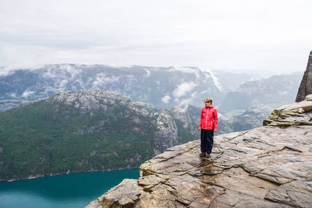 Girl on Prekestolen or Pulpit Rock in the rain. Norway.の写真素材