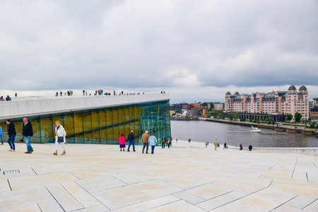 Oslo, Norway - June 16, 2019: Tourists near the modern Oslo Opera House. The national opera and...