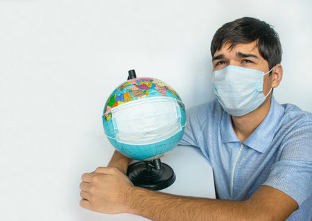 Guy and Earth globe in protective masks, as a symbol of the fact that people of entire planet are...