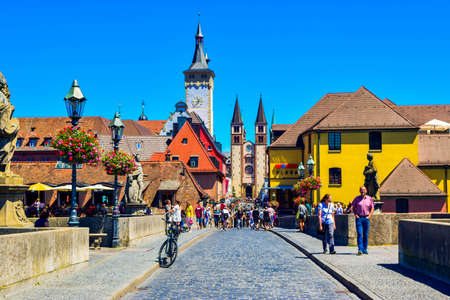 Wurzburg, Germany - July 4, 2019: View to old city and WÐ³rzburg Roman Catholic Cathedral of Saint Kilian from Old Main Bridge. Tourists and residents on street. Summer cityscape of Wuzburg.のeditorial素材