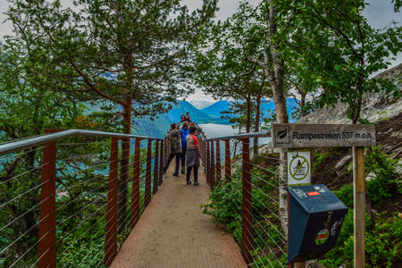 Andalsnes, Norway - June 28, 2019: Tourists on the Rampestreken viewpoint, located at an altitude of 537 above the Romsdalsfjord (Romsdal Fjord) and Romsdalen Valley. Rauma Municipality.のeditorial素材