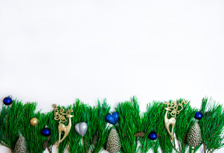 Pine branches decorated with Christmas toys and golden deer isolated on a white background....
