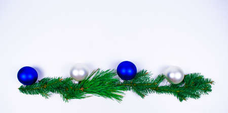 Pine branches decorated with Christmas balls on a white background. Christmas or New Year holiday greeting card. Copy space, template for lettering or text. Flat lay.の写真素材