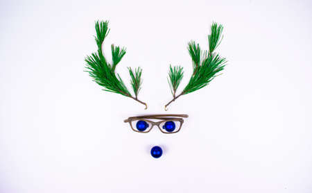 Christmas deer head made of pine branches and Christmas balls on a white background. Christmas and New Year minimalistic concept. Copy space, template for lettering or text. Flat lay.の写真素材
