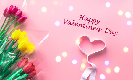 Valentine's Day Greeting Card. Fresh bouquets of tulips flowers with heart on delicate pastel light...