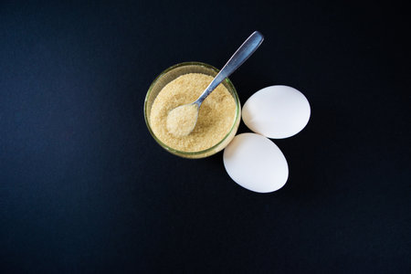 Gelatin and eggs are the main foods containing collagen, essential for youthful skin and healthy joints. The minimalist concept of proper nutrition. Black background. Flat lay, top view. Copy space.の写真素材