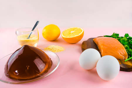 Foods containing collagen. Gelatin, eggs, fish, greens, citrus fruits containing collagen and are necessary for its synthesis for youthful skin and healthy joints. Light pink background. Copy space.の写真素材