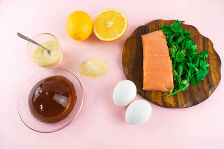 Foods containing collagen. Gelatin, eggs, fish, greens, citrus fruits containing collagen and are necessary for its synthesis for youthful skin and healthy joints. Light pink background. Copy space.の写真素材