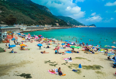Finale Ligure, Italy - 21 July 2019: Vacationers on the sandy Selva Beach on a summer, sunny day near the calm Mediterranean Sea. Ligurian Riviera coast.のeditorial素材