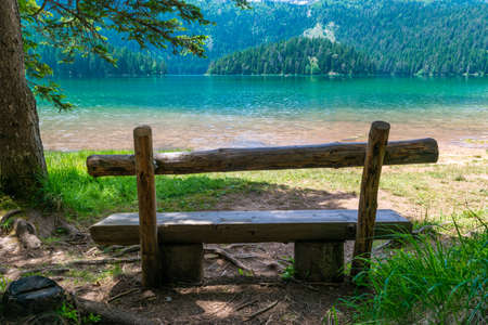 Wooden bench near Glacial Black Lake. Premium tourist attraction of Durmitor National Park. Walking path circles around lake, and is a popular destination for recreation and hiking. Montenegroの写真素材