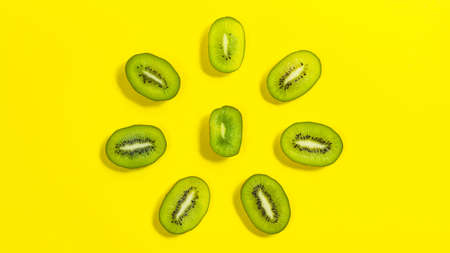 Kiwi slices form the shape of a flower. yellow background. copyspace. Concept of proper nutrition and healthy fruits.の写真素材