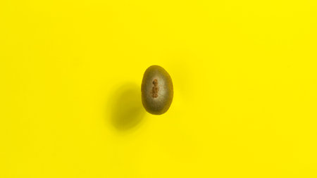 Brown kiwifruit. yellow background. copyspace. Concept of proper nutrition and healthy fruits....