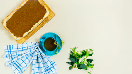 Blue cup with linden flowers tea. Cake, cloth napkin and branches of blossom lime. Concept of...